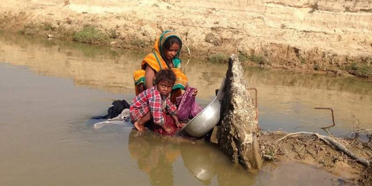 झापाको गौरीगञ्जमा ढलेको सीमास्तम्भमा लुगा धुन्छन् भारतीय नागरिक